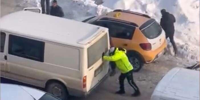 Trafik polisi mahsur kalan aracı iterek kurtardı