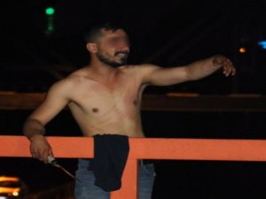 Yarı çıplak olan bir kişi ekmek bıçağı ile...